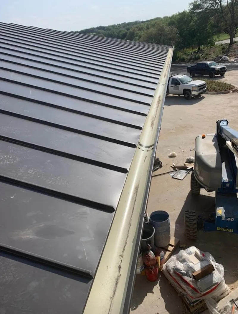 Standing seam panel and gutter detail on a metal roofing jobsite in Sheridan